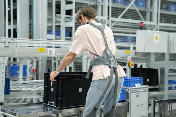 Warehouse worker wearing Exomove Lift during material handling